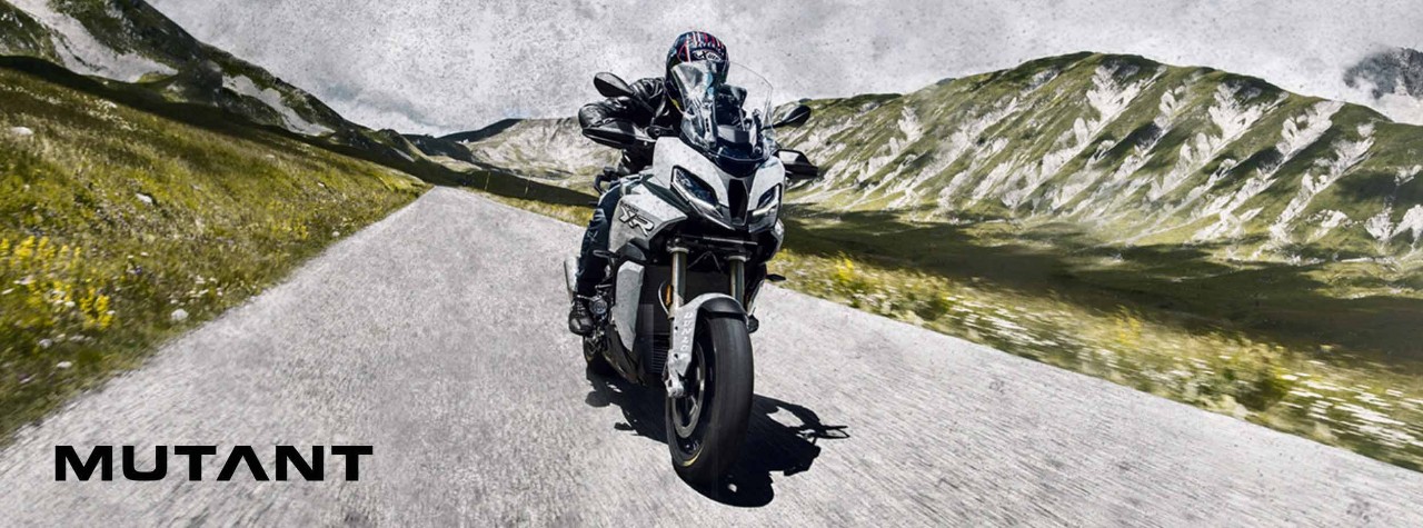 BMW S 1000 XR montado sobre neumáticos Dunlop Mutant con montañas al fondo atrás
