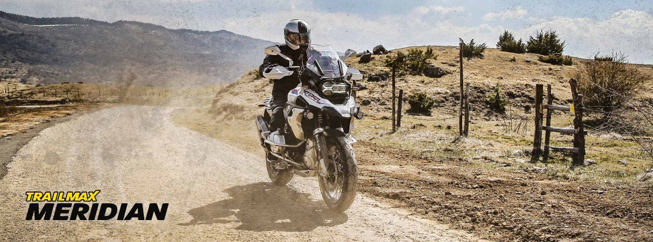 Piloto aventurero en las montañas con neumáticos Dunlop Trailmax Meridian